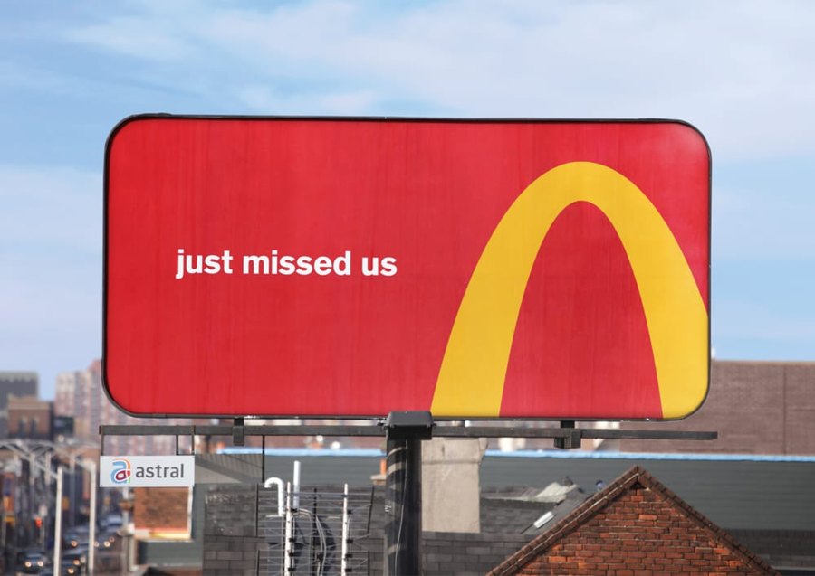 McDonald’s Follow the Arches billboard: a cropped yellow arch and small white directional words on red